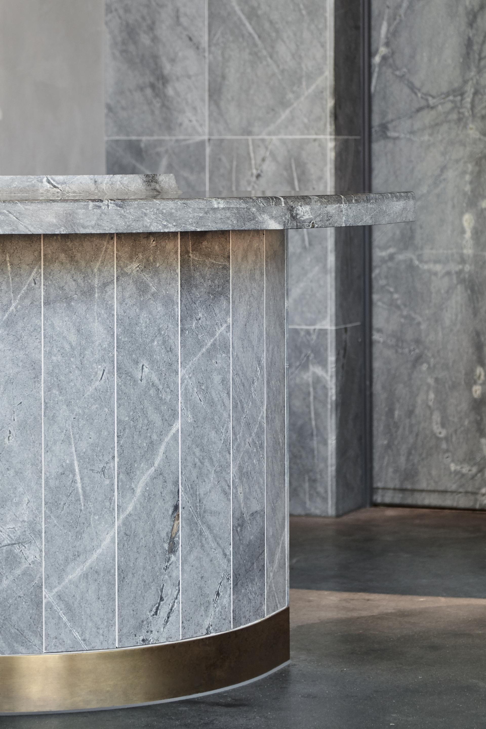 Stylish gray stone reception desk showcasing elegant design and sophisticated materials in a modern hospitality environment.