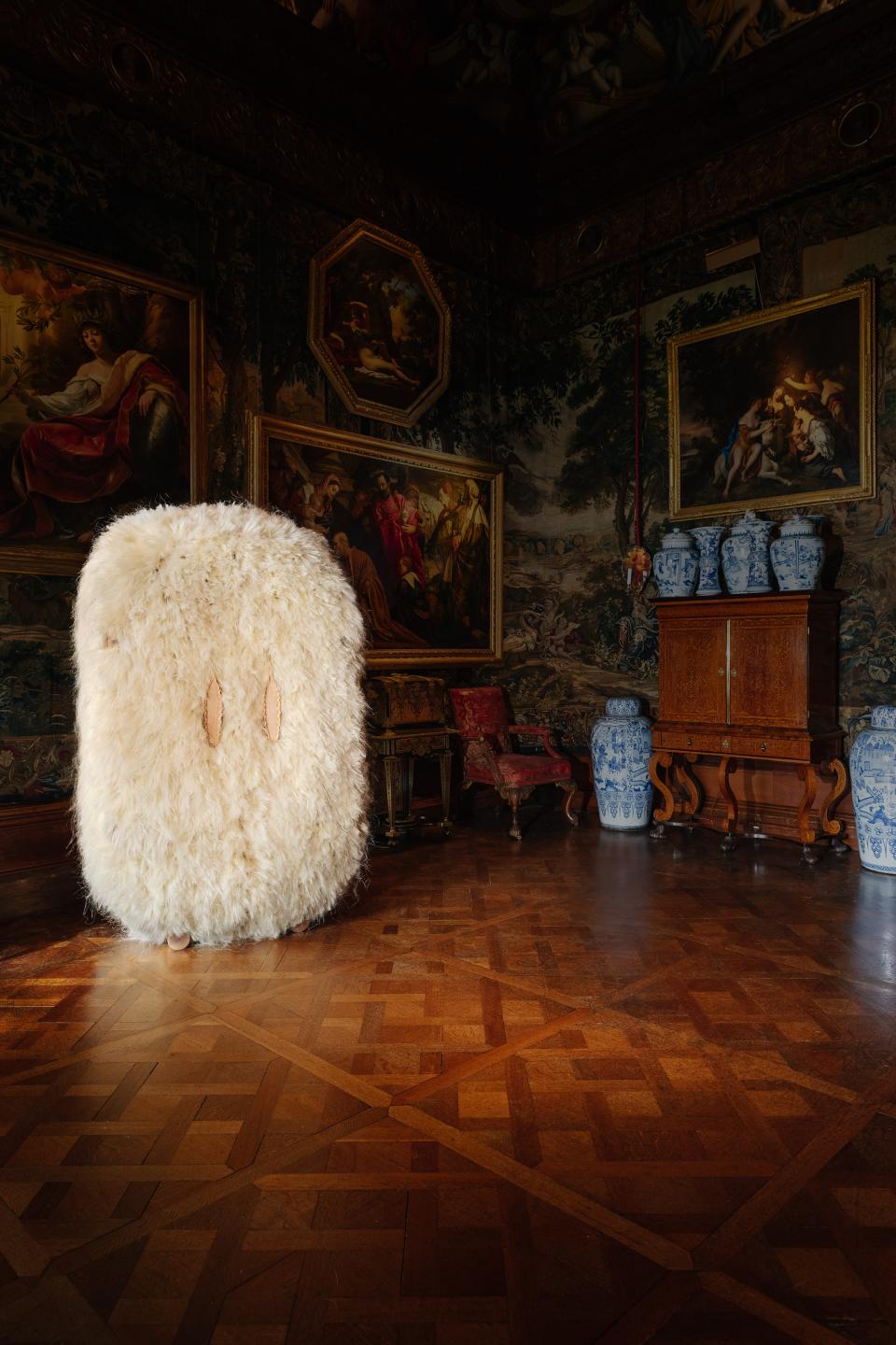 Fluffy white art piece stands in Chatsworth House's lavishly decorated room, showcasing rich heritage and materiality.