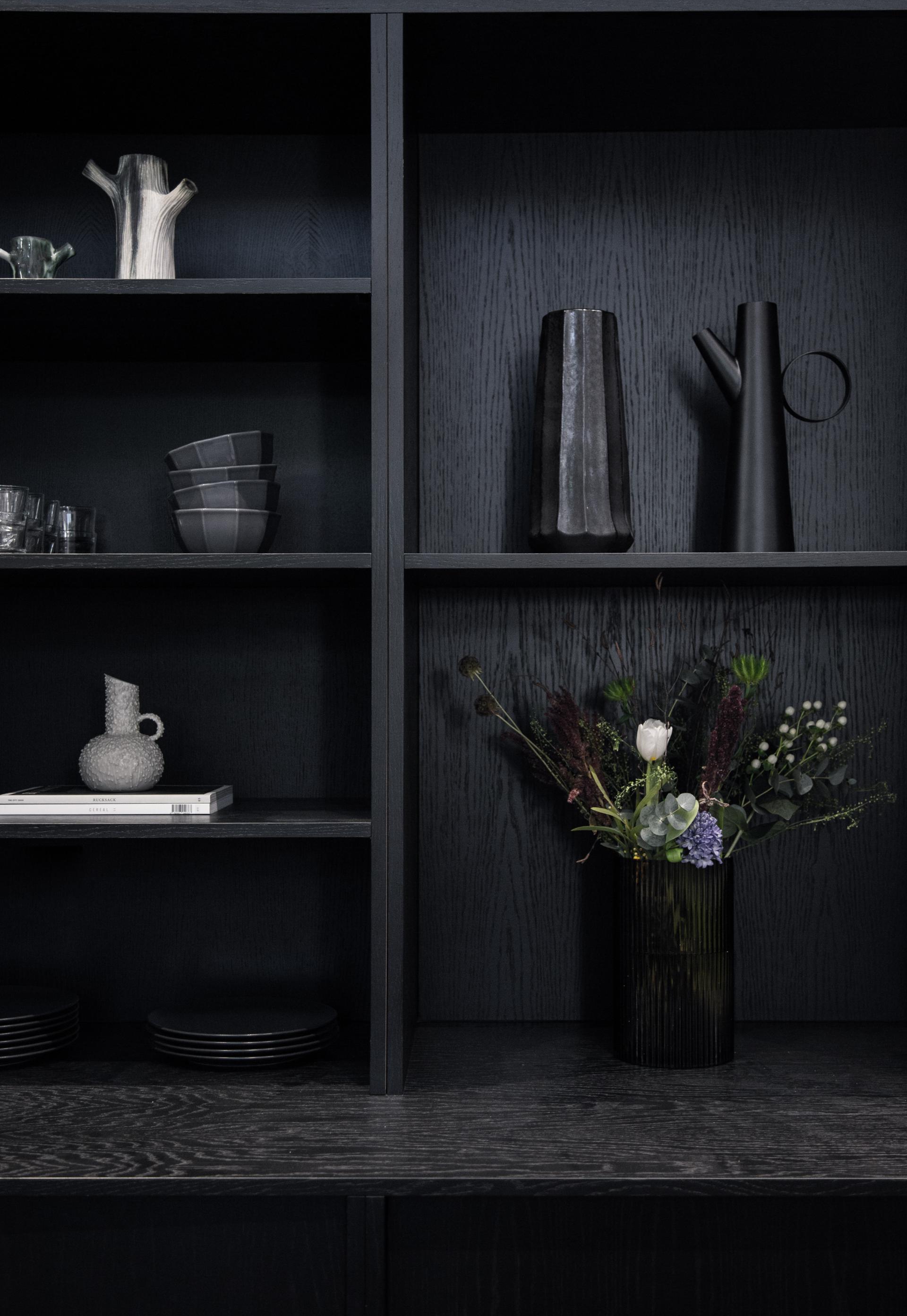 Modern shelving with elegant tableware and a chic floral arrangement, reflecting contemporary design influences in Manchester.
