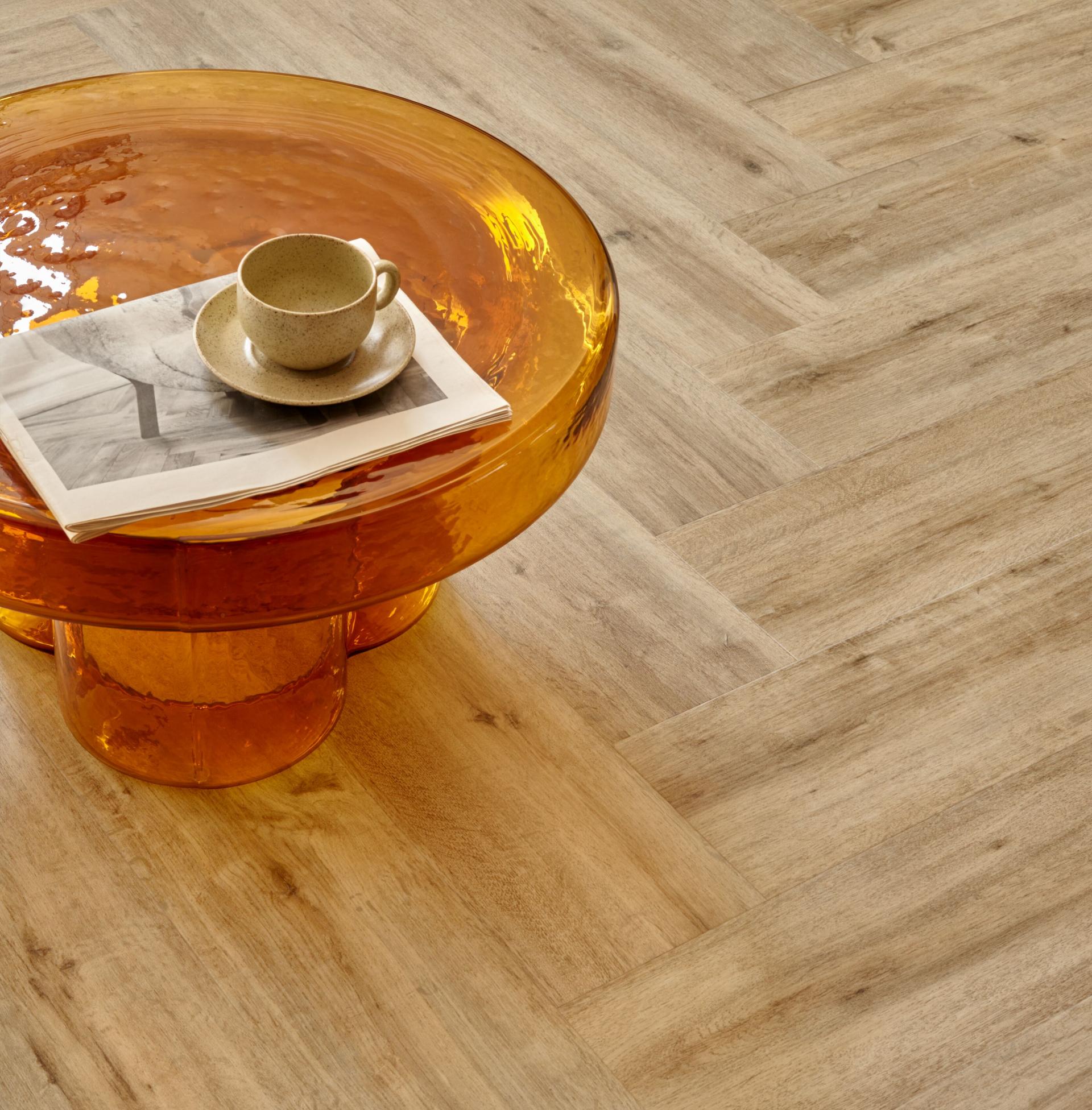 Stylish amber table with a cup and magazine on Allura Decibel Luxury Vinyl Tile flooring, creating a serene space.