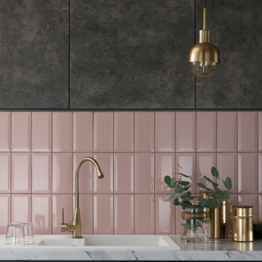 Modern kitchen featuring sleek pink and dark tiles, a stylish gold faucet, and elegant decor elements.