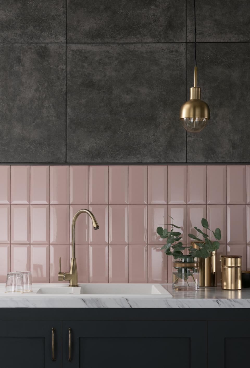 Modern kitchen featuring sleek pink and dark tiles, a stylish gold faucet, and elegant decor elements.