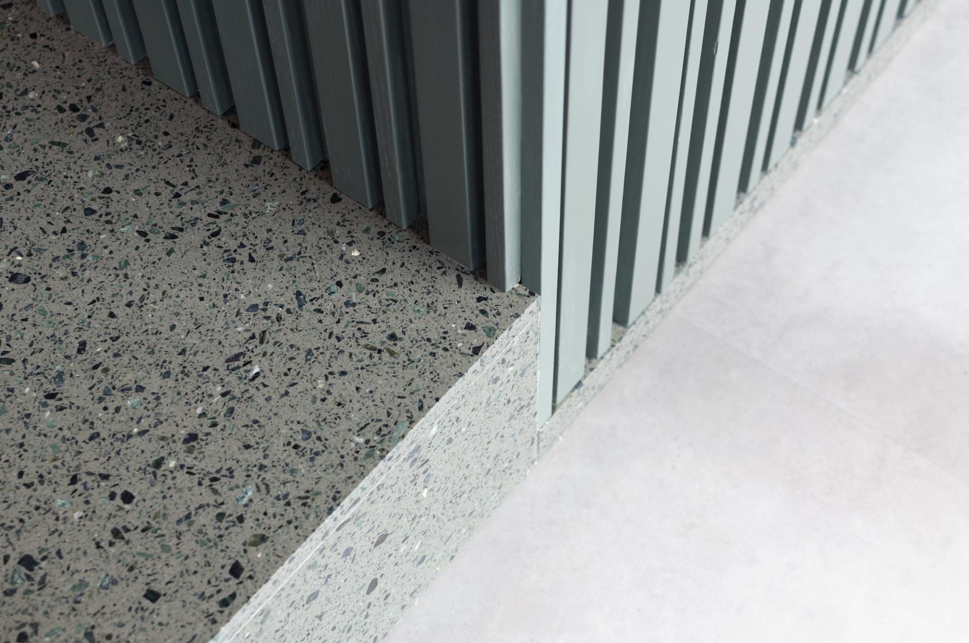 Textured stone surface and vertical slatted wall detail in Warner Music Hong Kong's newly designed headquarters by Bean Buro.