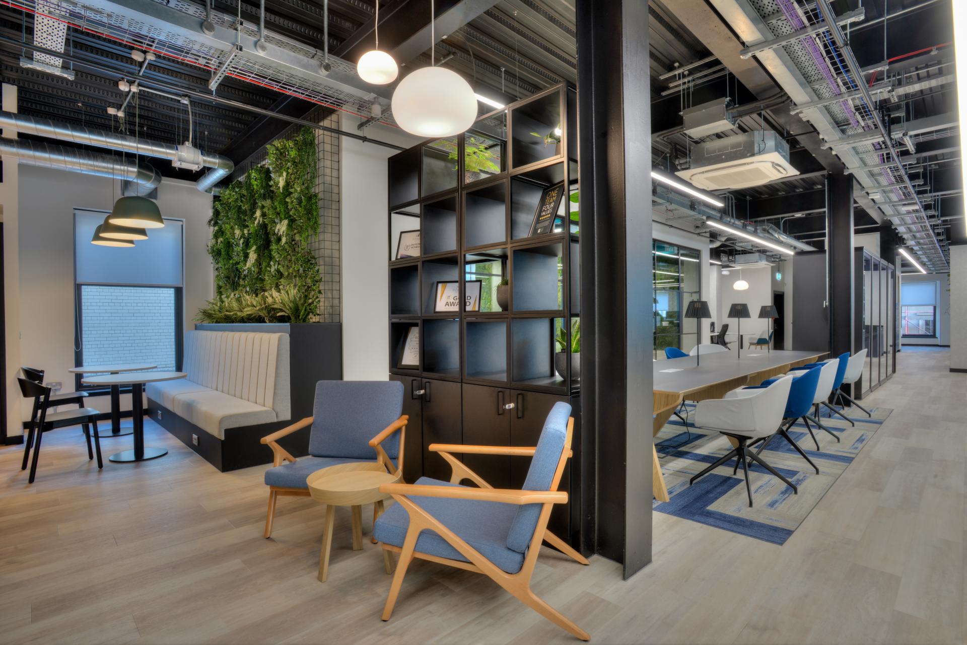 Modern workspace featuring Danish minimalism, with stylish furniture, greenery, and a bright, open layout for creativity.