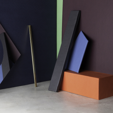 Textured, breathable performance textiles in various colors, inspired by Bauhaus design aesthetics, displayed in a modern setting.