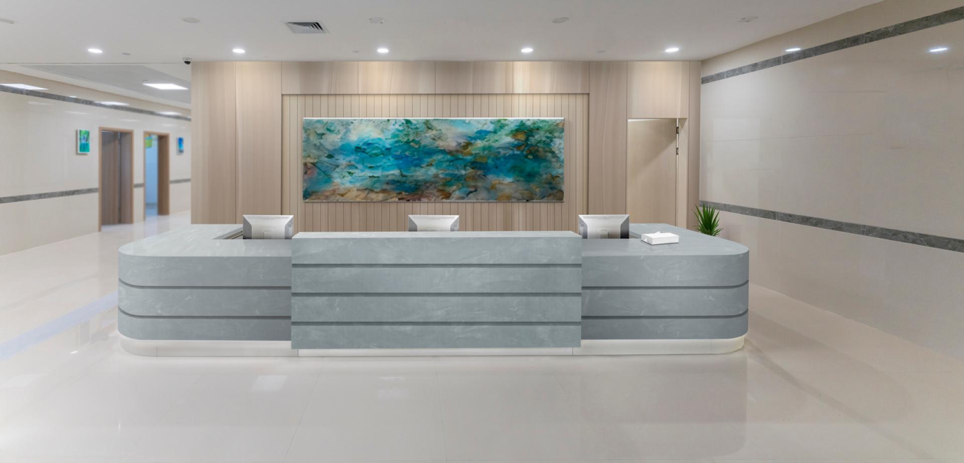 Modern reception area featuring sleek Corian® surfaces, inspired by nature, complemented by vibrant artwork.