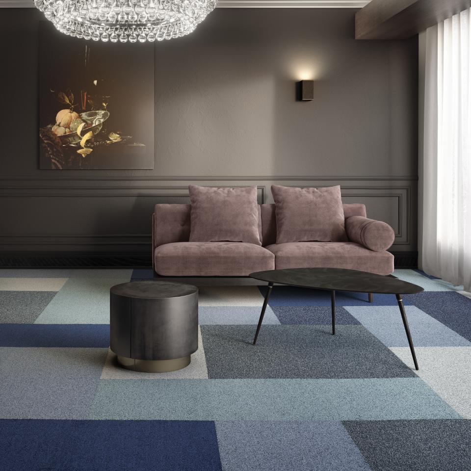 Luxurious interior featuring modulyss Delight carpet tiles, a stylish sofa, and sleek table, showcasing contemporary design and metallic accents.