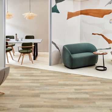 Stylish commercial interior featuring Amtico's Signature LVT flooring, contemporary furniture, and a colorful abstract wall design.