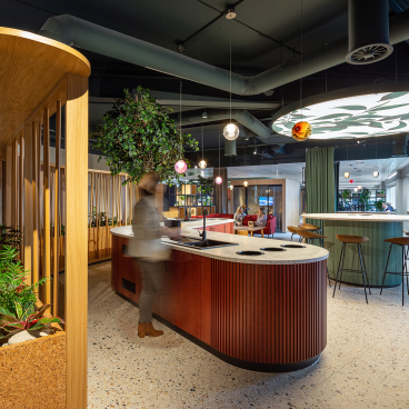 Modern workspace interior of PZ Cussons headquarters featuring a stylish bar area, greenery, and collaborative seating spaces.