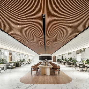 Modern coffee shop interior designed by Karv One, featuring wooden accents, elegant furniture, and lush greenery.