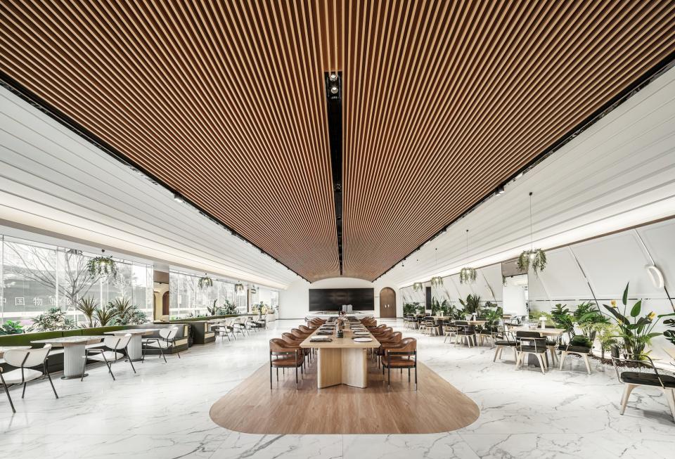 Modern coffee shop interior designed by Karv One, featuring wooden accents, elegant furniture, and lush greenery.