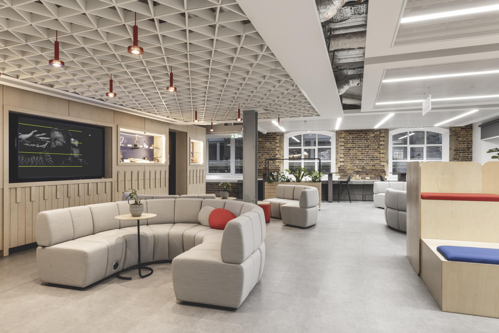 Modern office interior featuring unique multi-use seating, textured walls, and a stylish ceiling design for PRS for Music.