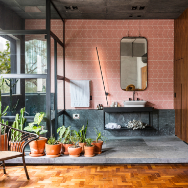 Modern bathroom design featuring natural elements, greenery, and pink geometric tiles, highlighting Apto Paulista's harmonious aesthetic.
