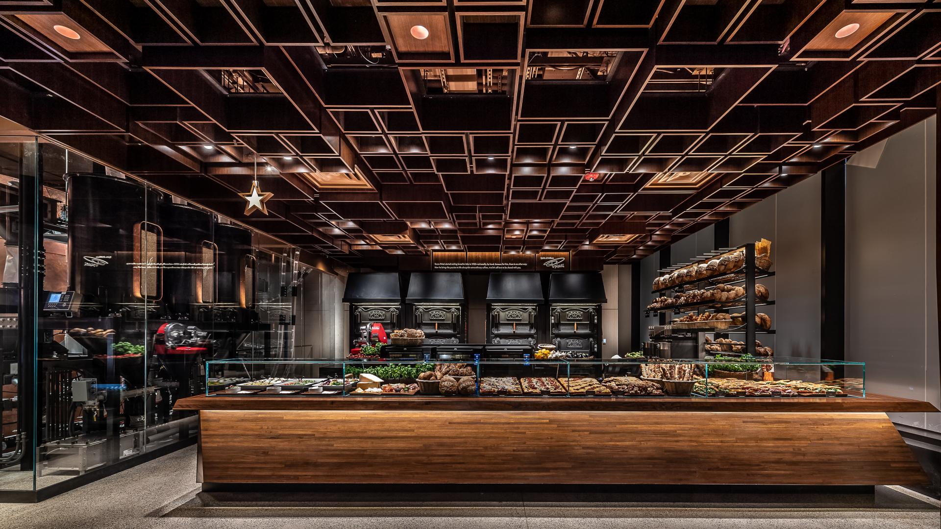 Elegant interior of Starbucks Reserve Roastery in New York, featuring a bakery display and premium coffee equipment.
