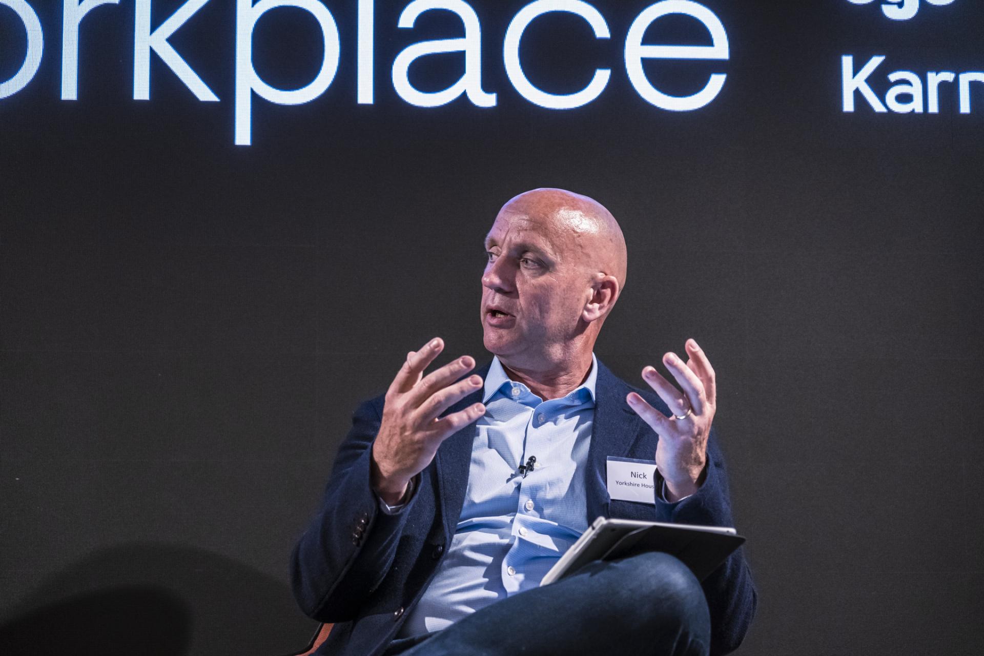 Panel discussion on the future of the workplace with an engaging speaker presenting insights and ideas.