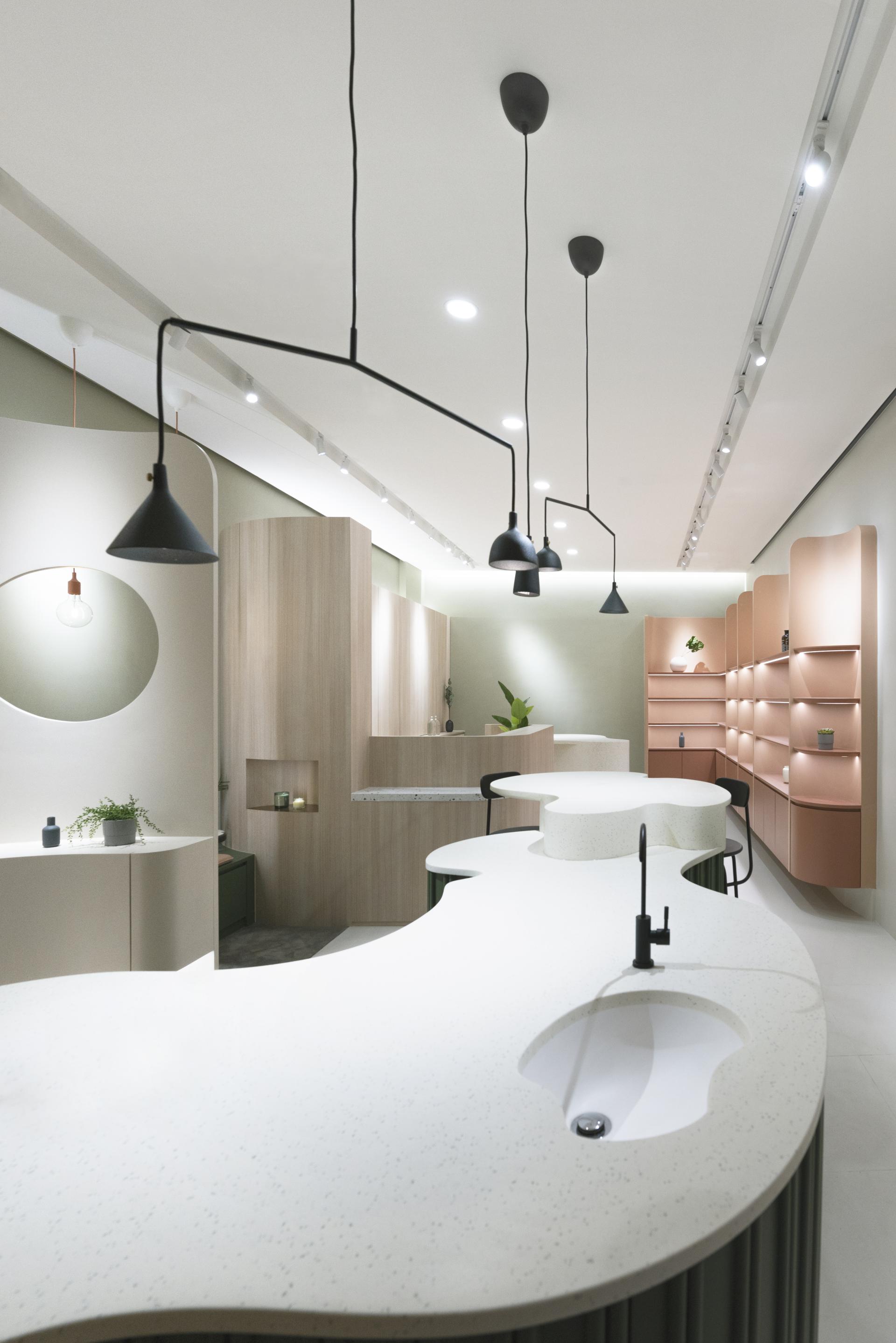 Sculptural interior of a flagship organic skincare store featuring soft curves, minimalist design, and ambient lighting.