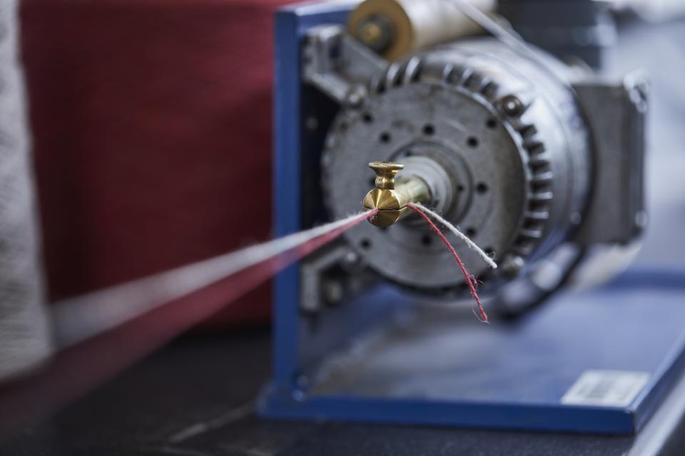 Tweed textile machinery showcasing wool and flax threads used in Camira's innovative Main Line Twist collection.