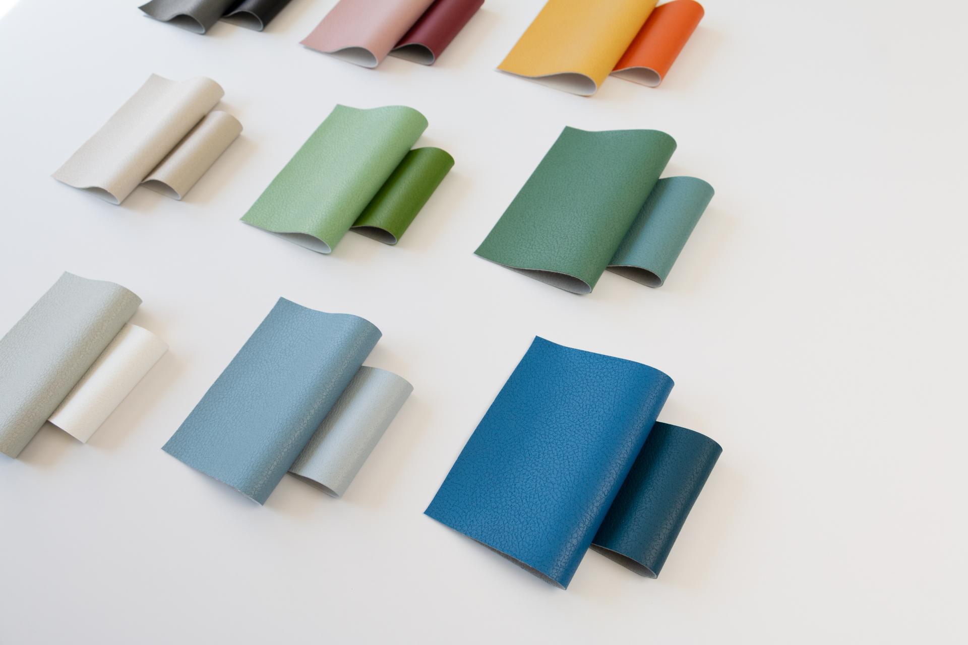 Colorful samples of Brisa's recycled upholstery fabric made from plastic bottles, showcasing various textures and hues.