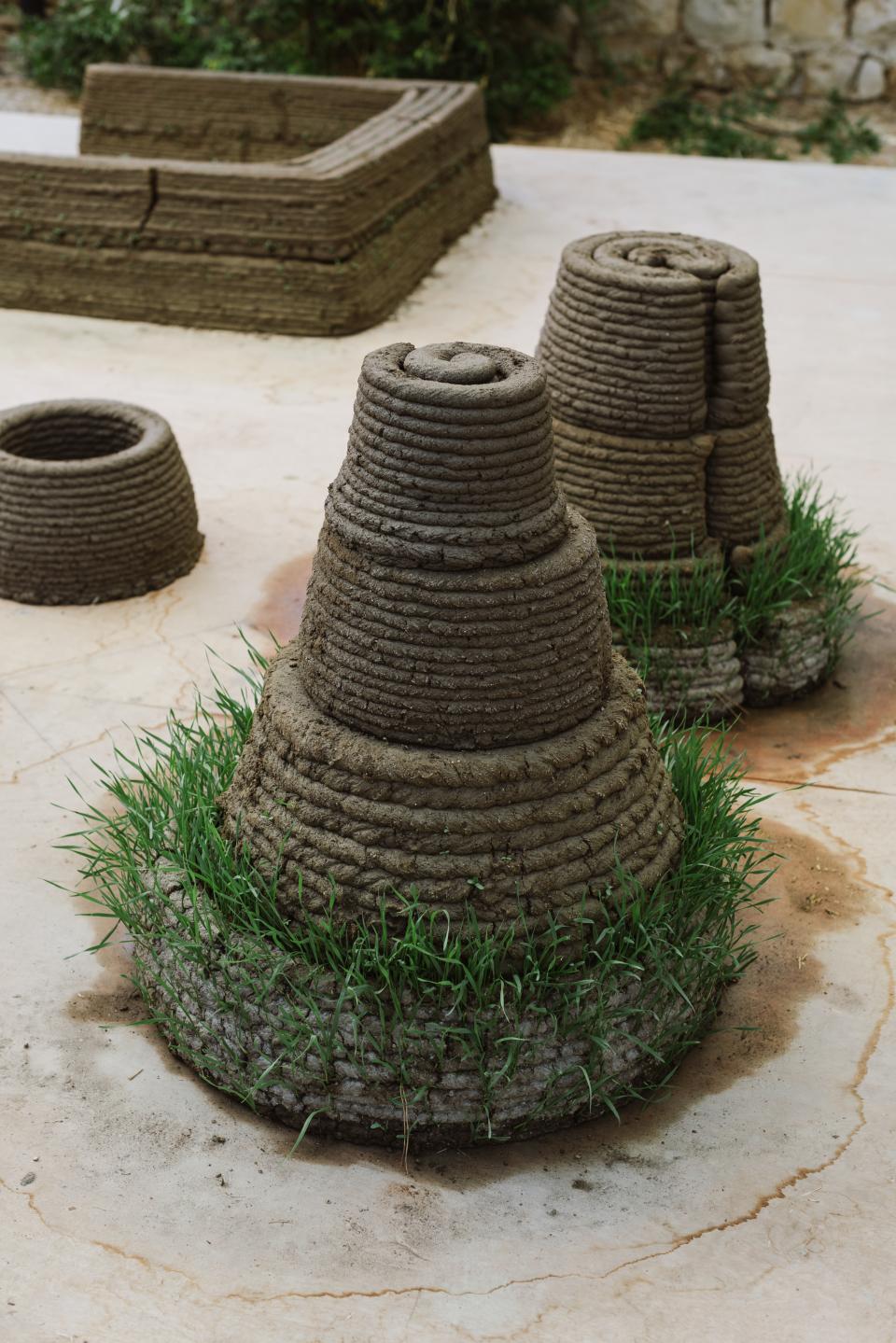 3D-printed structures made of soil and grass, showcasing innovative construction techniques at Jerusalem Design Week 2022.