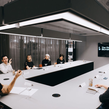 A group discussion on biomaterials takes place around a modern conference table, emphasizing sustainability and innovation.