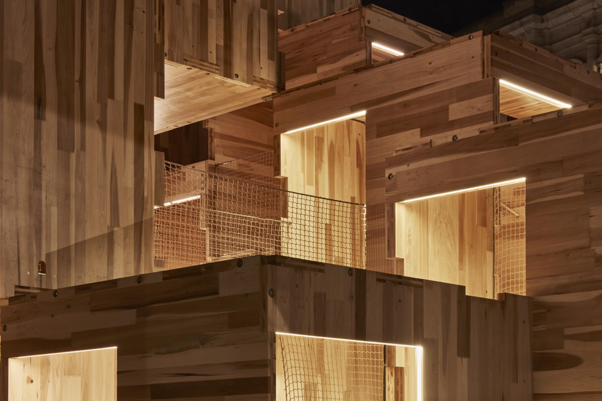 Carbon-neutral wooden pavilion, MultiPly, showcasing intricate American tulipwood design with illuminated features.