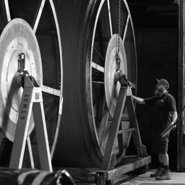 Worker monitoring production machinery in Forbo's Telford factory, highlighting sustainable flooring systems, celebrating 100 years of Nuway.