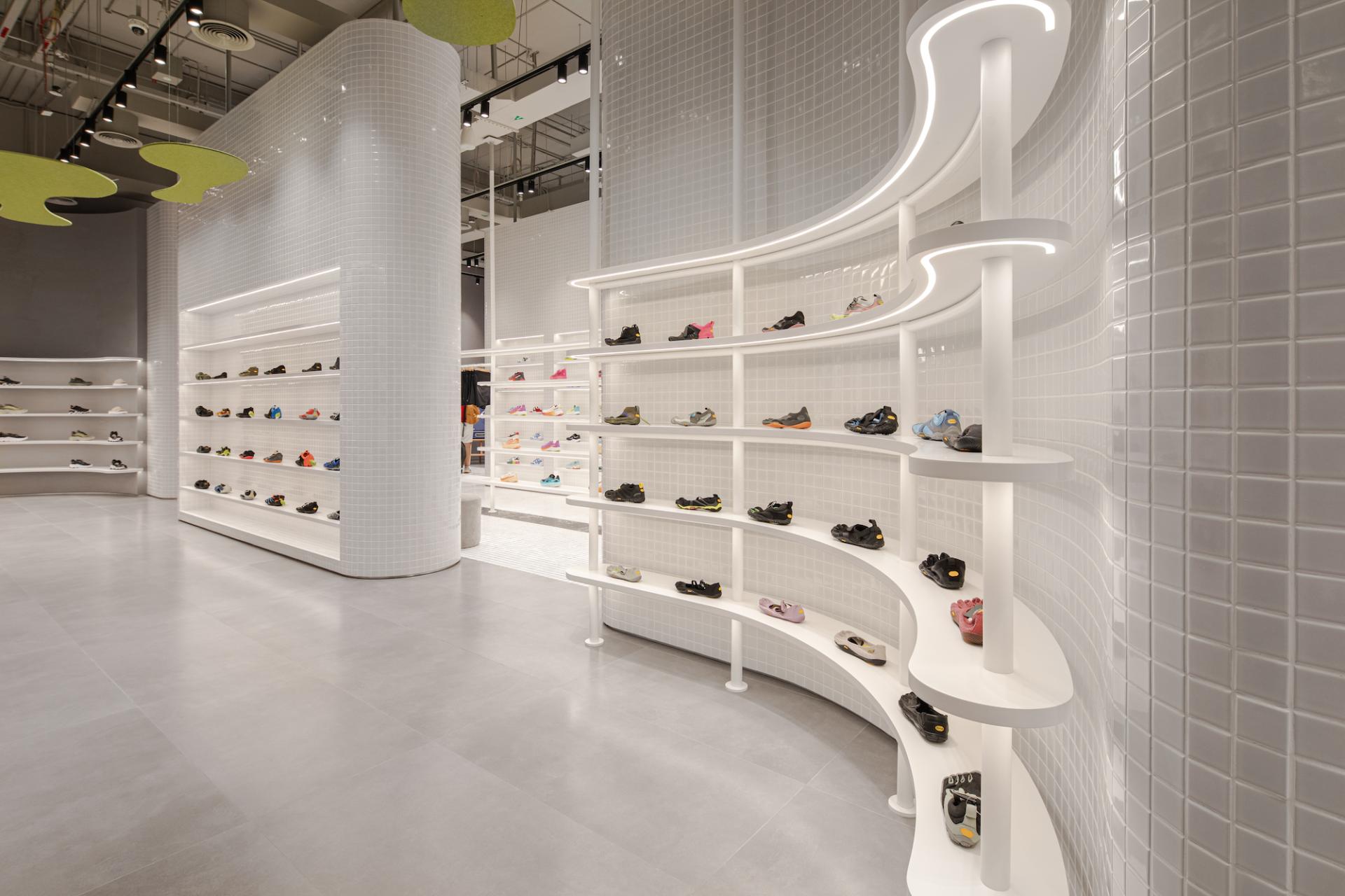 Stylish display of vibrant activewear shoes on sleek white shelves in a modern concept store in Dubai.