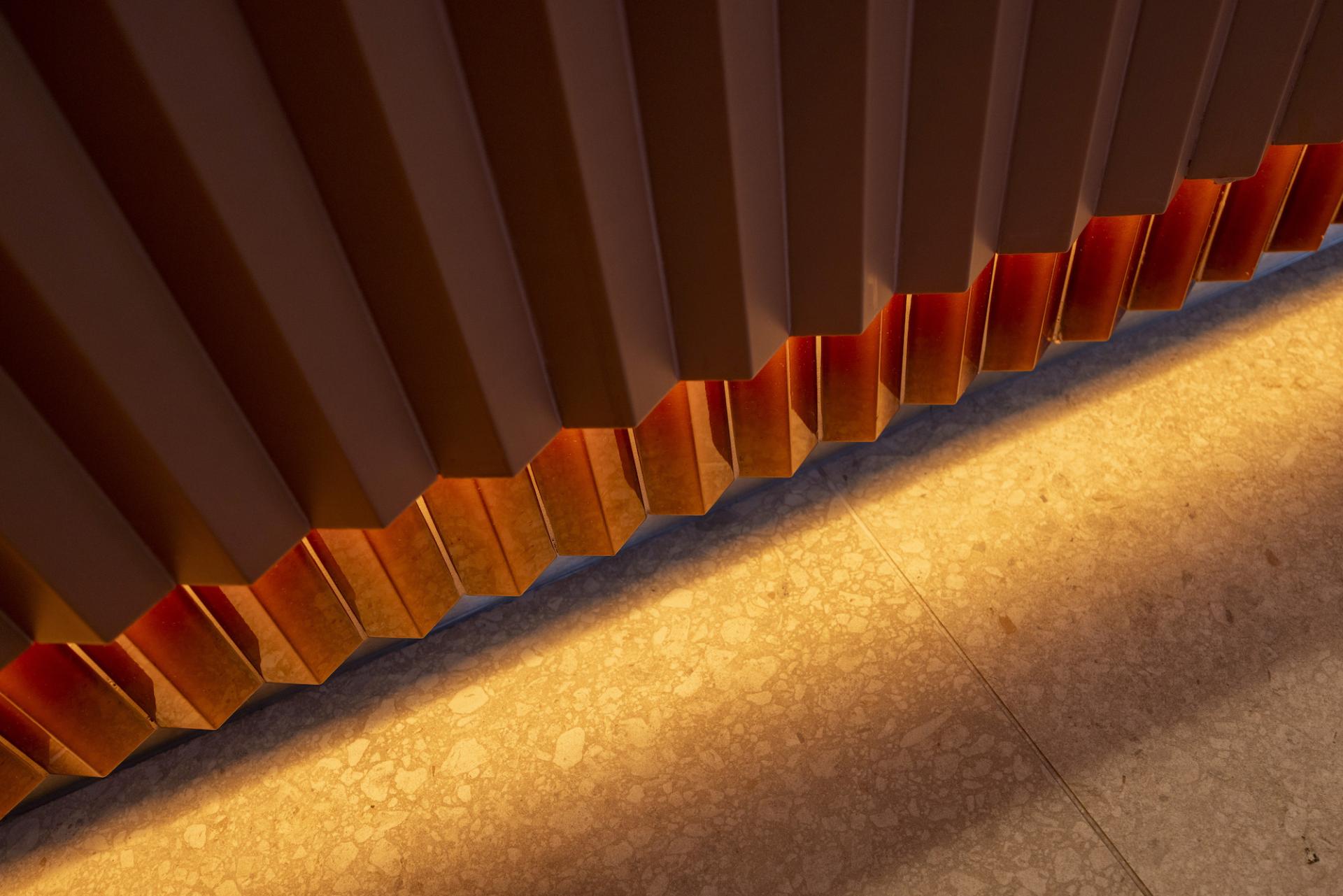 Textured wall detail with soft lighting, showcasing innovative design elements at Junction, Manchester Central.