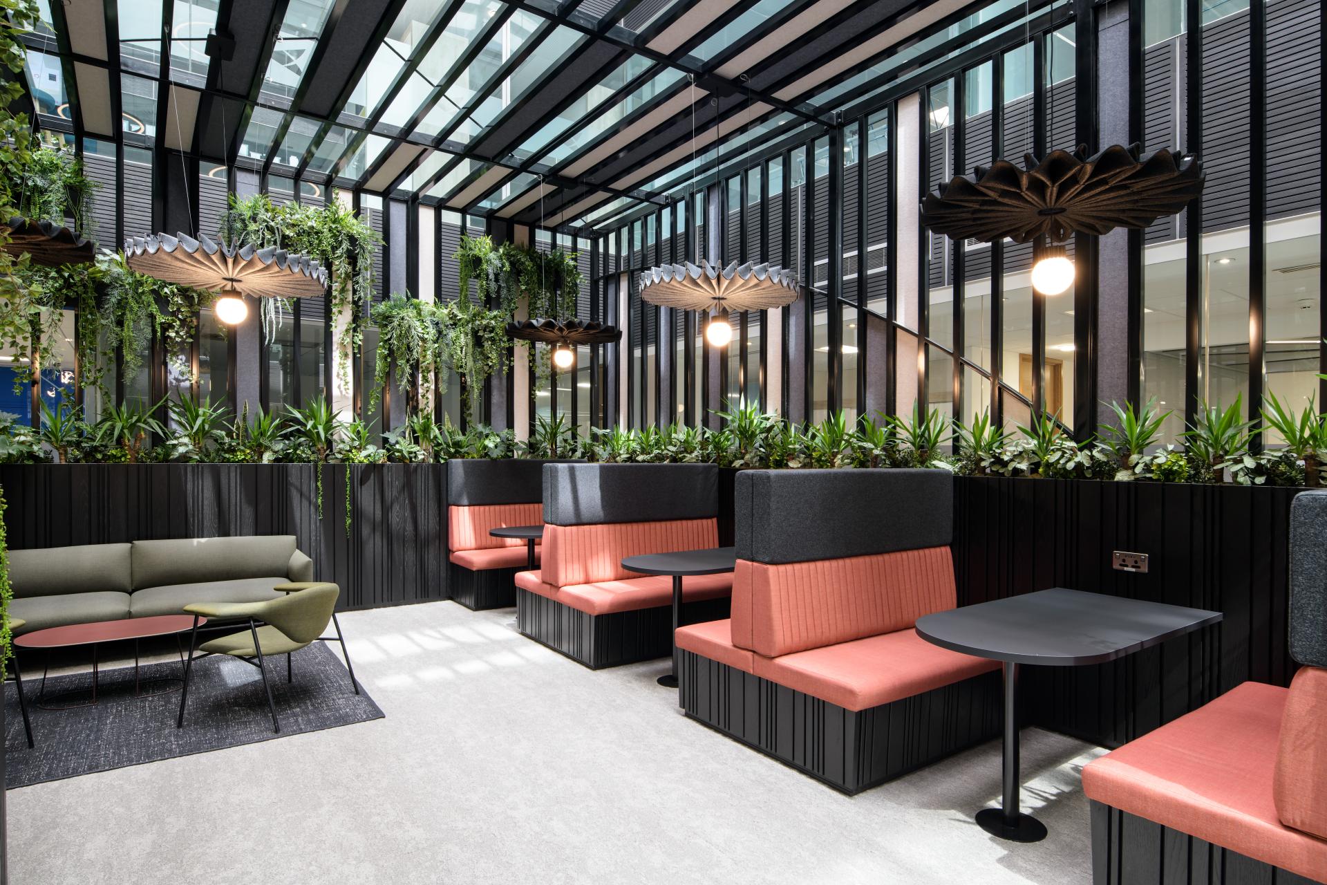 Modern interior design featuring cozy seating and lush greenery at One Piccadilly Gardens, transformed by SpaceInvader.