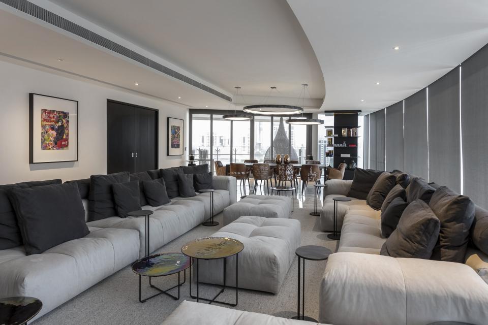 Modern living room featuring plush gray seating, artistic decor, and a stylish dining area in an upscale Singapore apartment.
