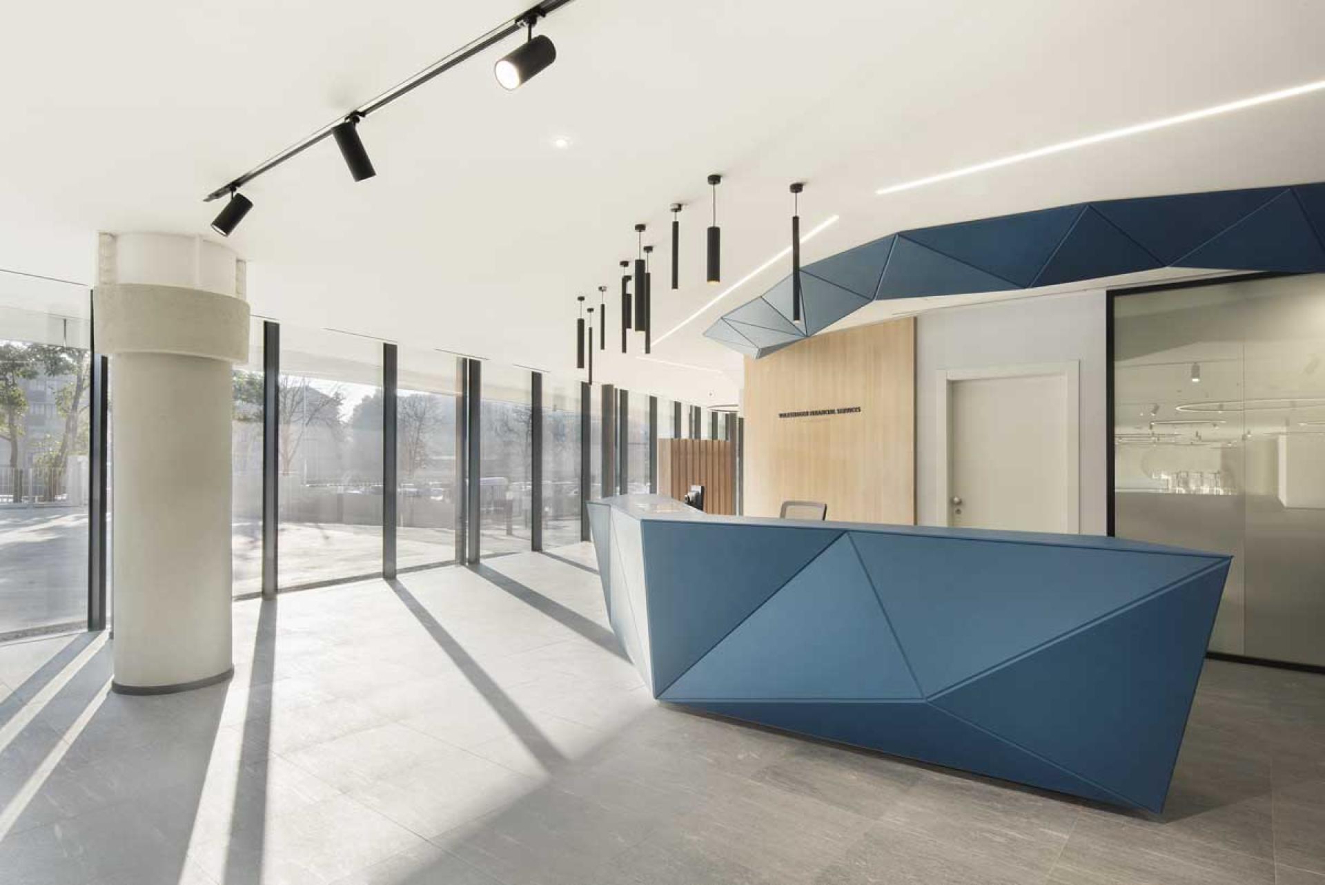Modern reception area featuring geometric design elements, natural light, and contemporary finishes for Volkswagen Financial Services headquarters.