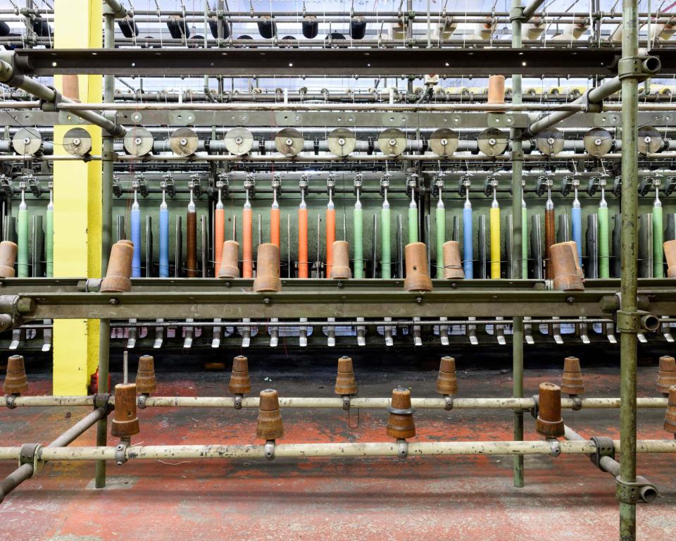 Textile production machinery with colorful threads, highlighting Kvadrat's innovative upholstery fabric manufacturing process in Denmark.