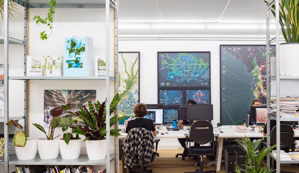 Contemporary architecture studio featuring creative workspaces, architectural models, and vibrant plant life highlighting Dutch design.