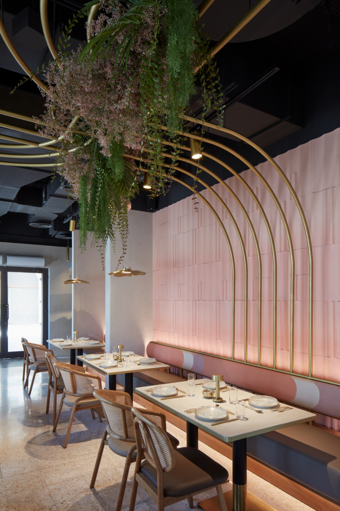 Stylish dining area featuring elegant decor, gold accents, and lush greenery, showcasing Roar studio's innovative interior design.