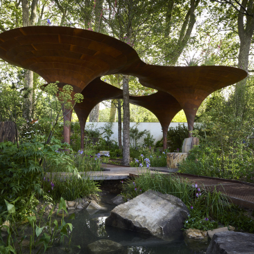 Resilient garden design featuring innovative rainwater collection structure surrounded by lush greenery and tranquil water features.