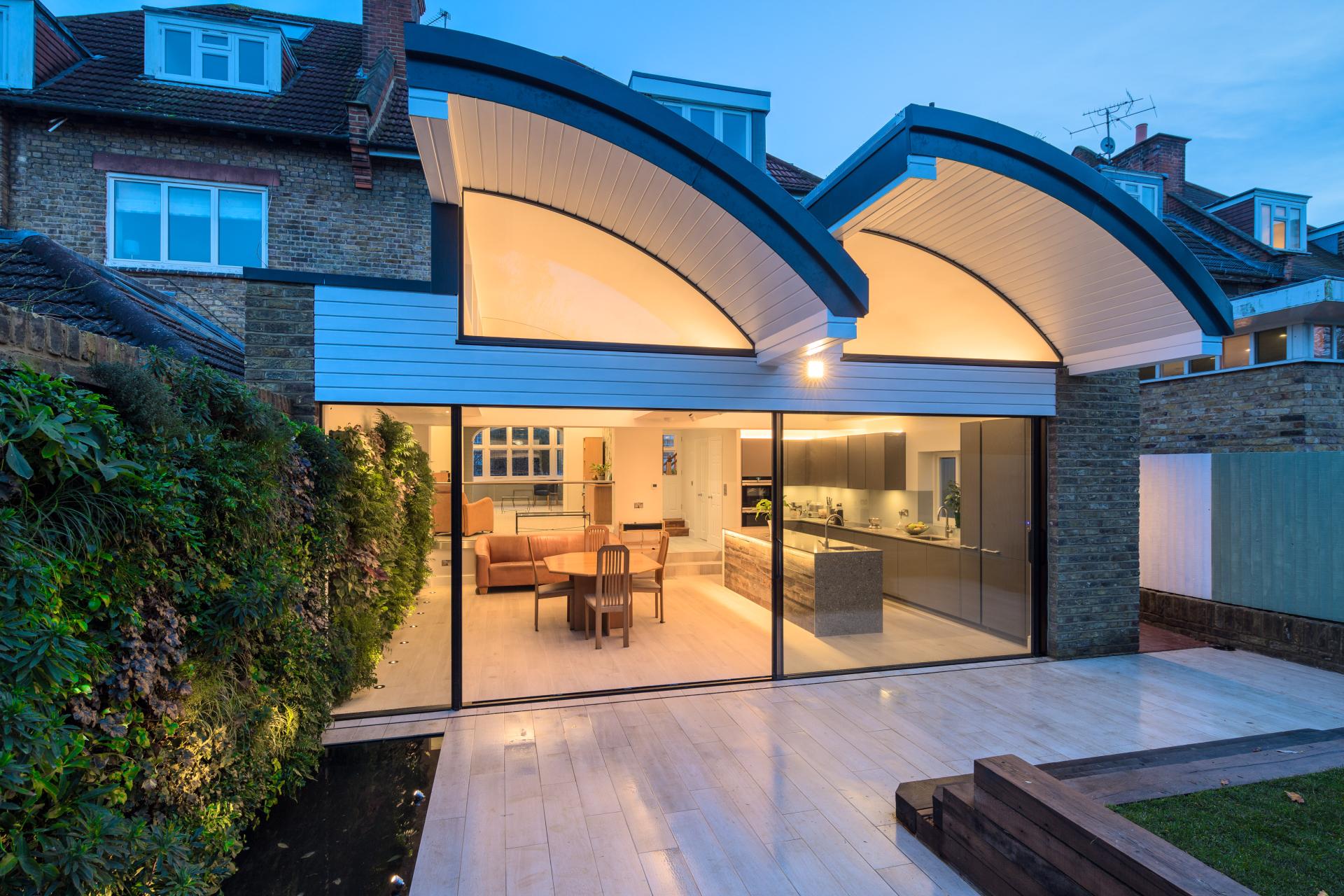 Modern home design featuring large glass doors and elegant lighting, highlighting Nulty’s expertise in interior lighting.