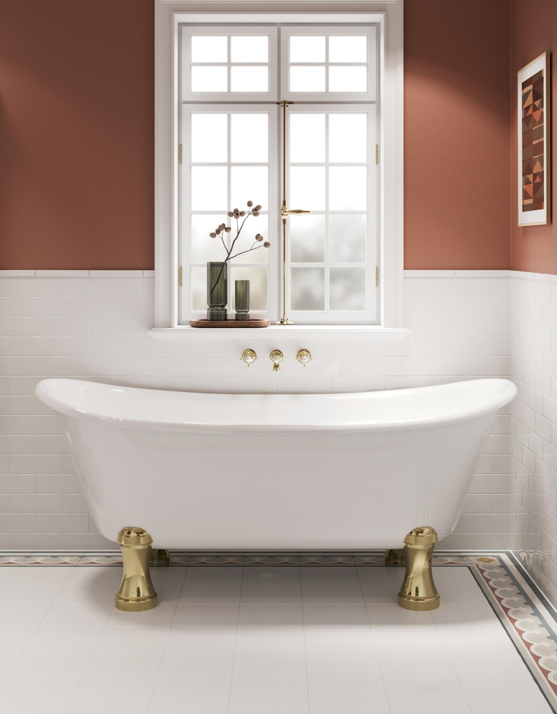 Classic freestanding bathtub with brass feet, set against a warm-toned wall and stylish window, highlighting Arts & Crafts design elements.
