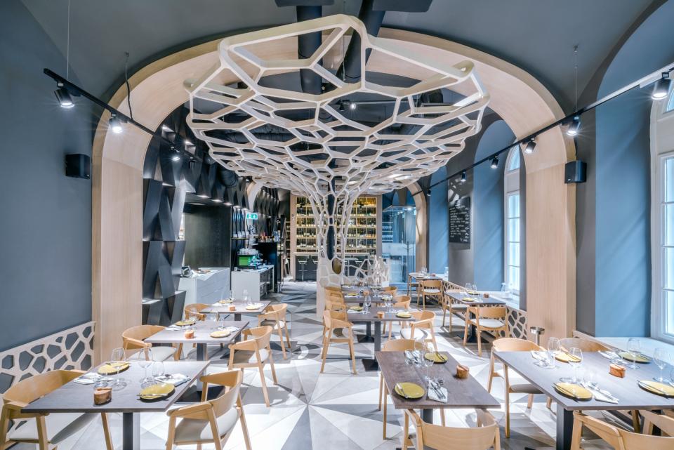 Modern dining area of Textúra restaurant featuring intricate parametric wood ceiling design and elegant table settings.