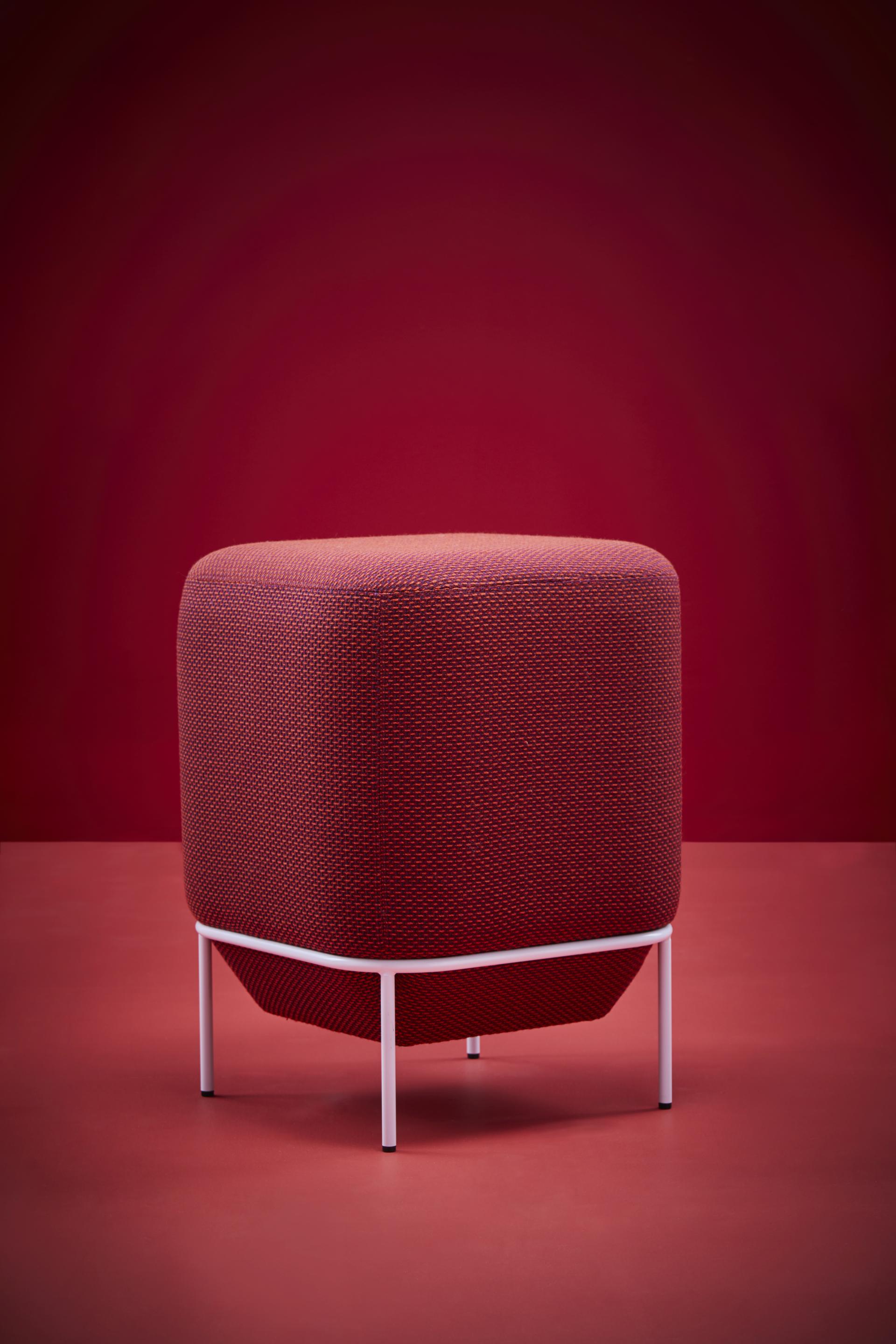 Stylish red upholstered ottoman with a sleek white metal frame, showcasing comfort and modern design.