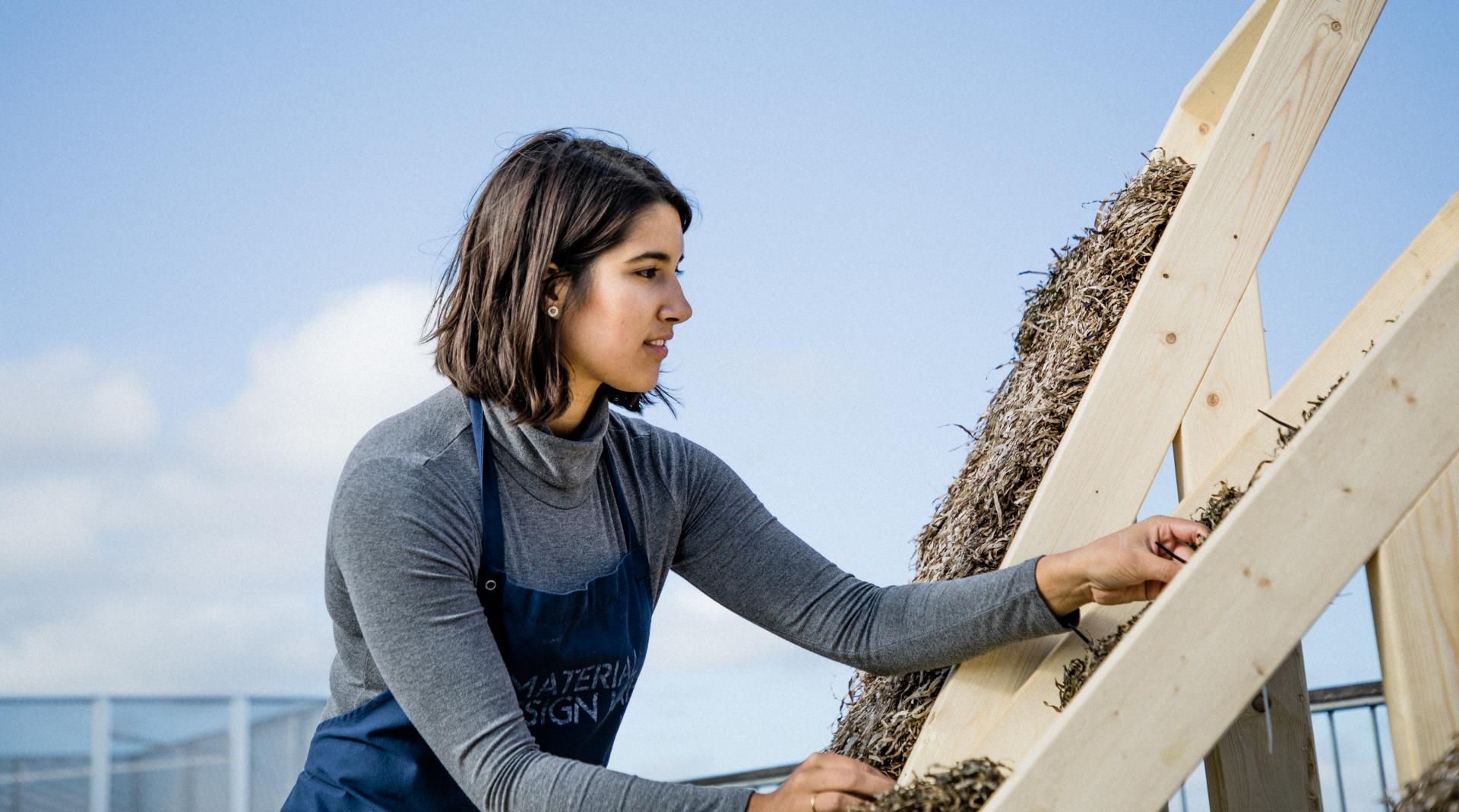 Biomaterial designer working on sustainable building materials with natural fibers, showcasing innovative eco-friendly design solutions.