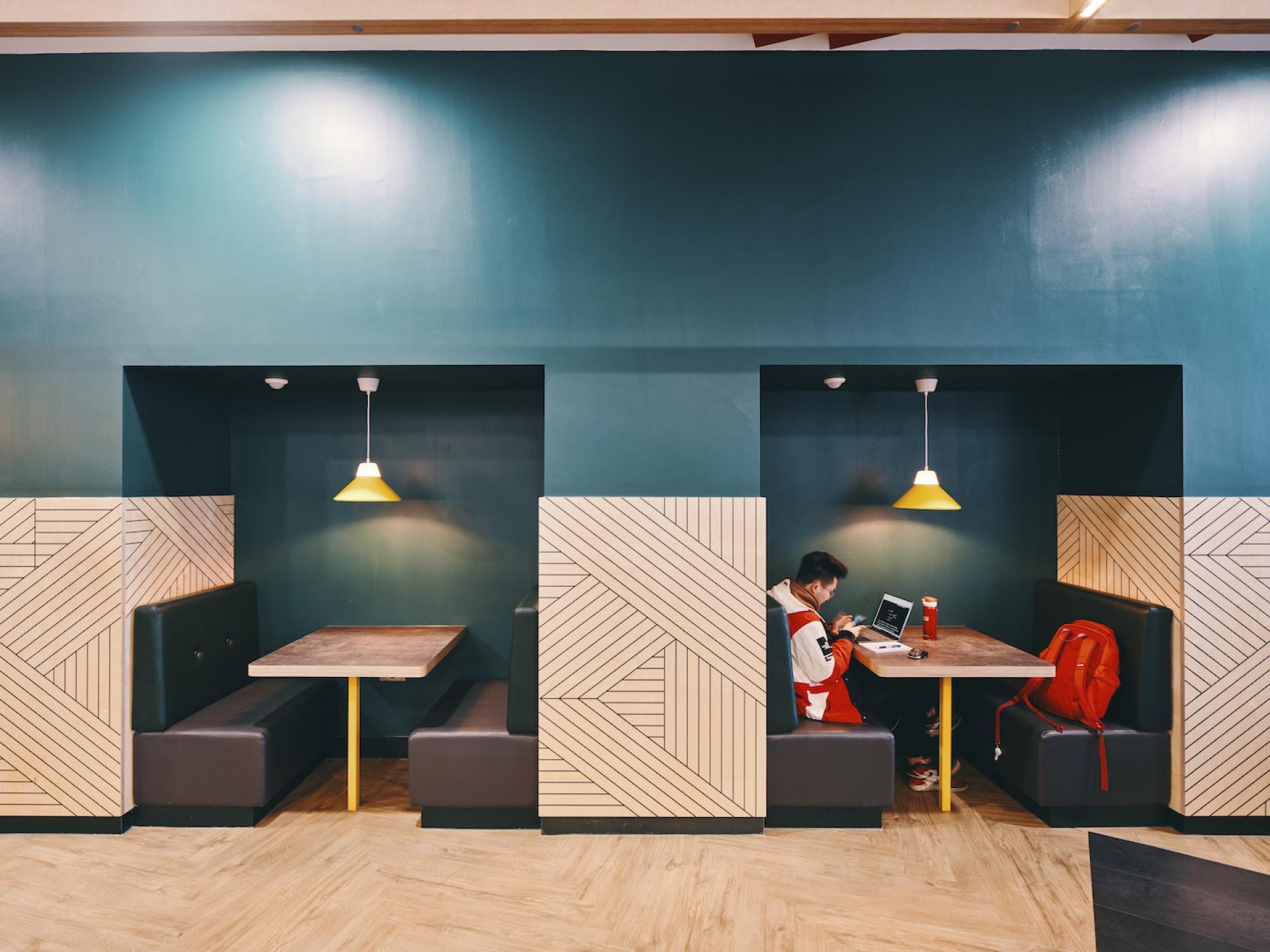 Modern study booths with stylish design, featuring a student working on a laptop at Knight House, University of Sheffield.