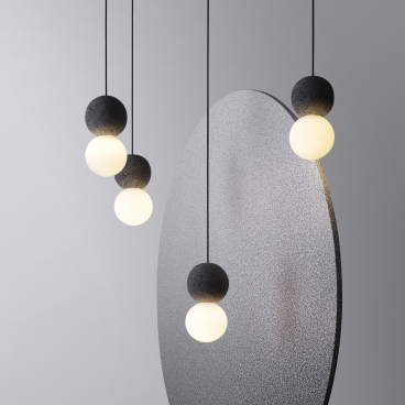 Origo lighting collection features geometric designs with black volcanic rock and glass, highlighting innovative contemporary aesthetics.