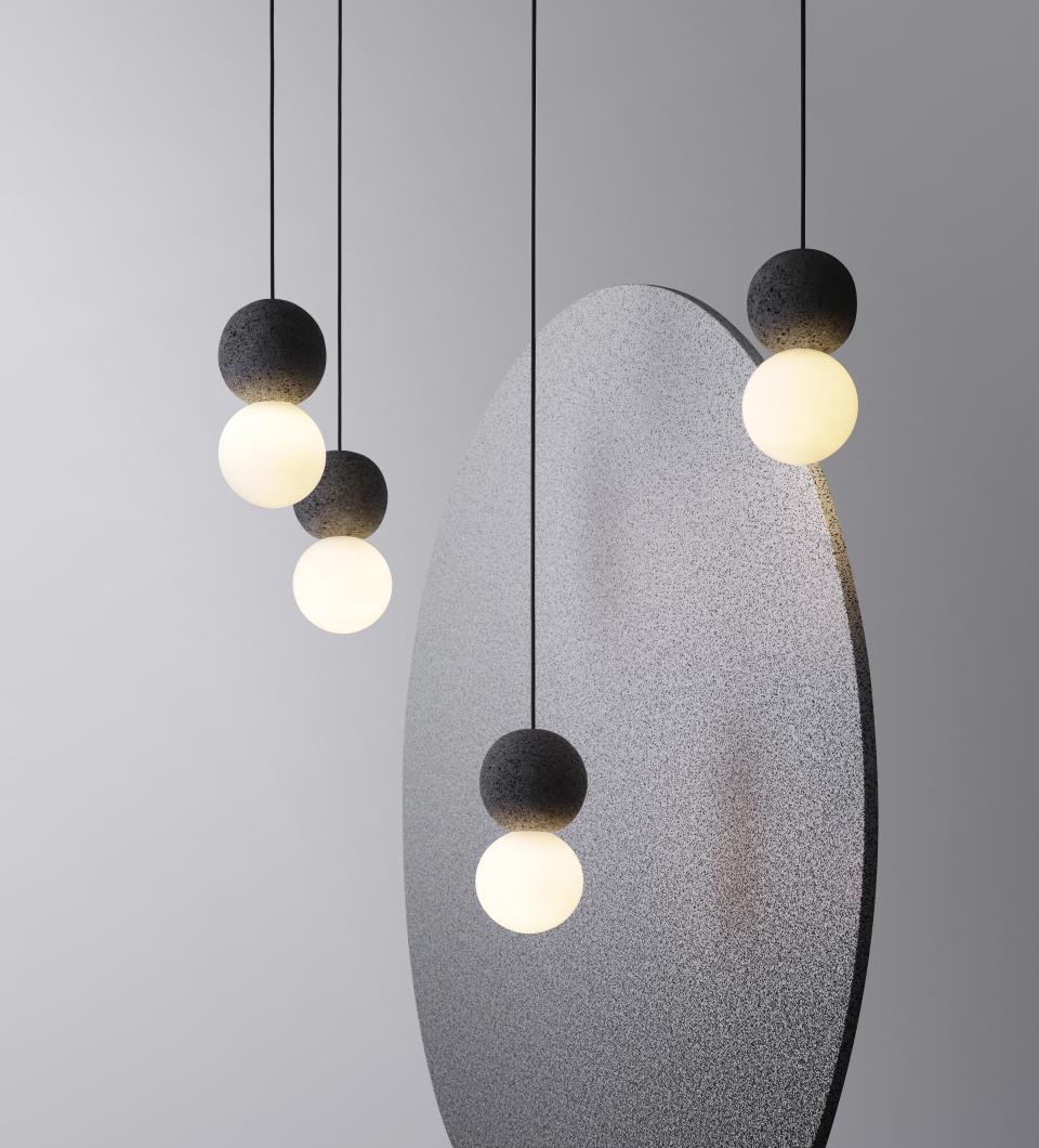 Origo lighting collection features geometric designs with black volcanic rock and glass, highlighting innovative contemporary aesthetics.