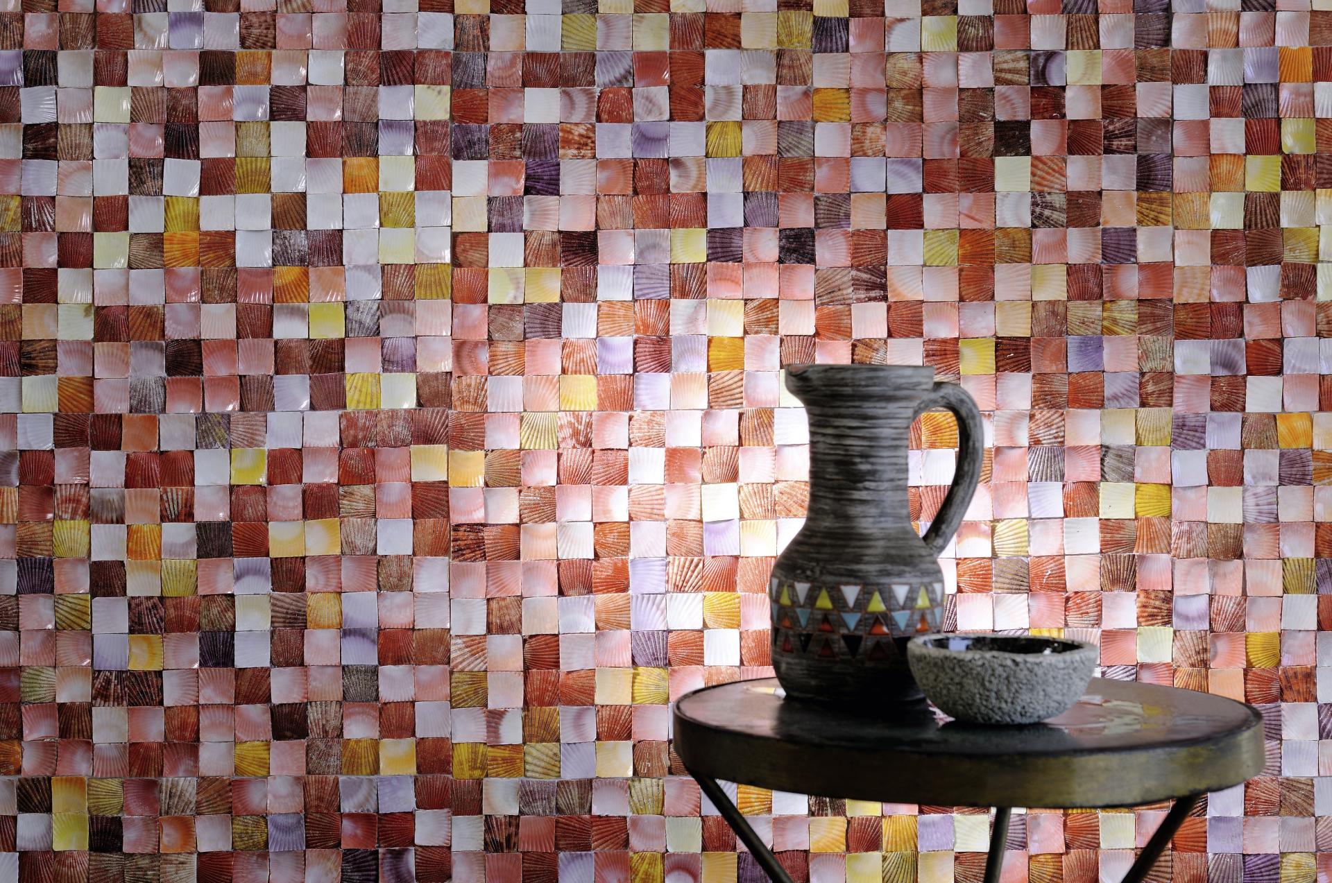 Colorful patterned wall tiles compliment a ceramic pitcher and bowl on a round table, showcasing innovative design at Paris Design Week.