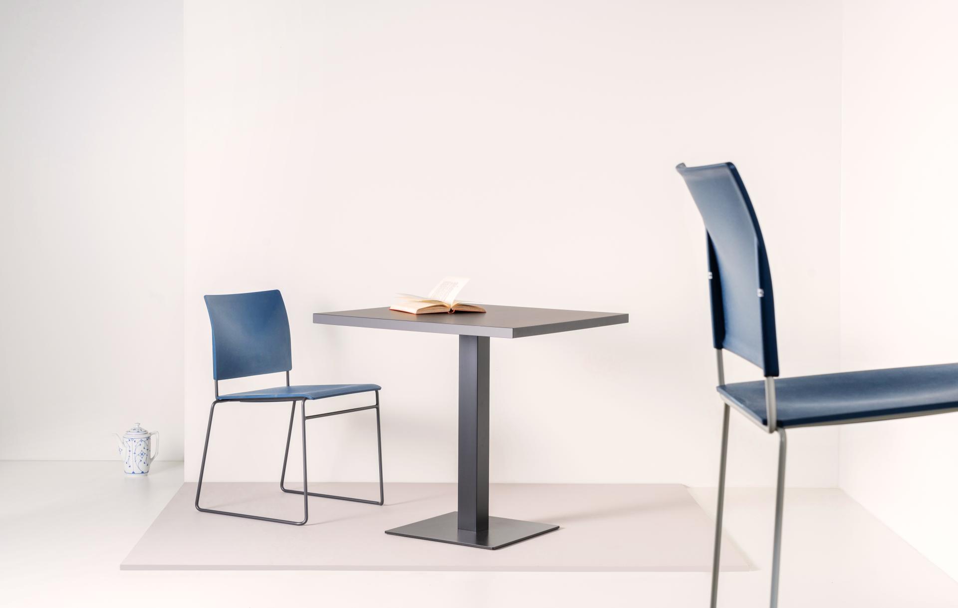 Sustainable blue Finn stools and a table create a minimalist setting, showcasing eco-friendly design and innovative use of materials.
