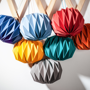Colorful paper crafts arranged in a geometric pattern, showcasing creative craftsmanship in Glasgow's vibrant arts scene.