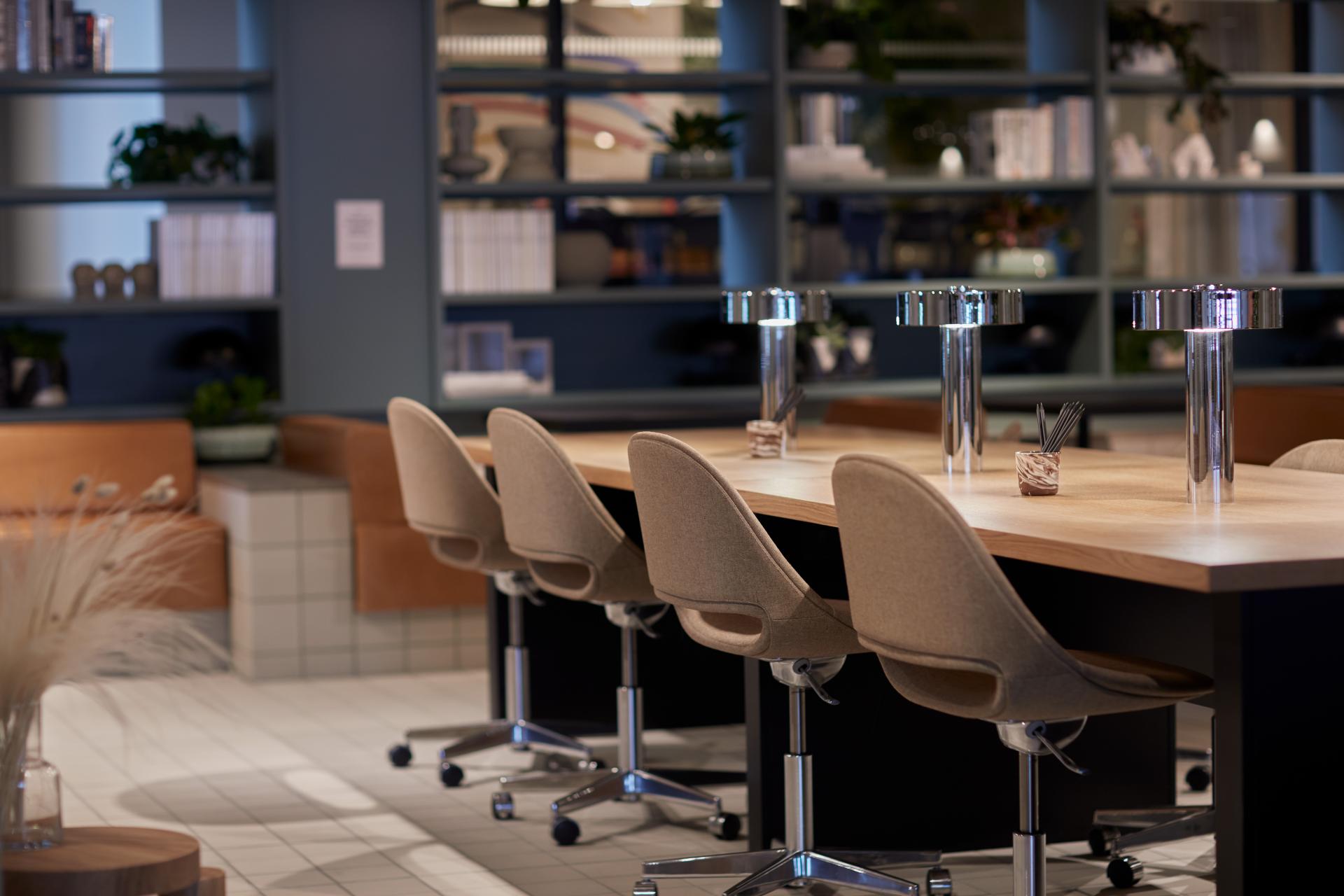 Modern collaborative workspace in Notting Hill with stylish seating and decorative shelving, designed for creativity and productivity.