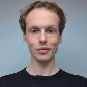 William Lee, lead designer at Giles Miller Studio, poses with a thoughtful expression against a neutral background.