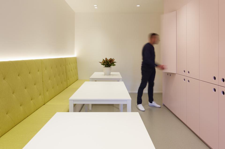 Brightly colored workspace featuring green seating, white tables, and storage cabinets, designed by Studio Y for Ambience.