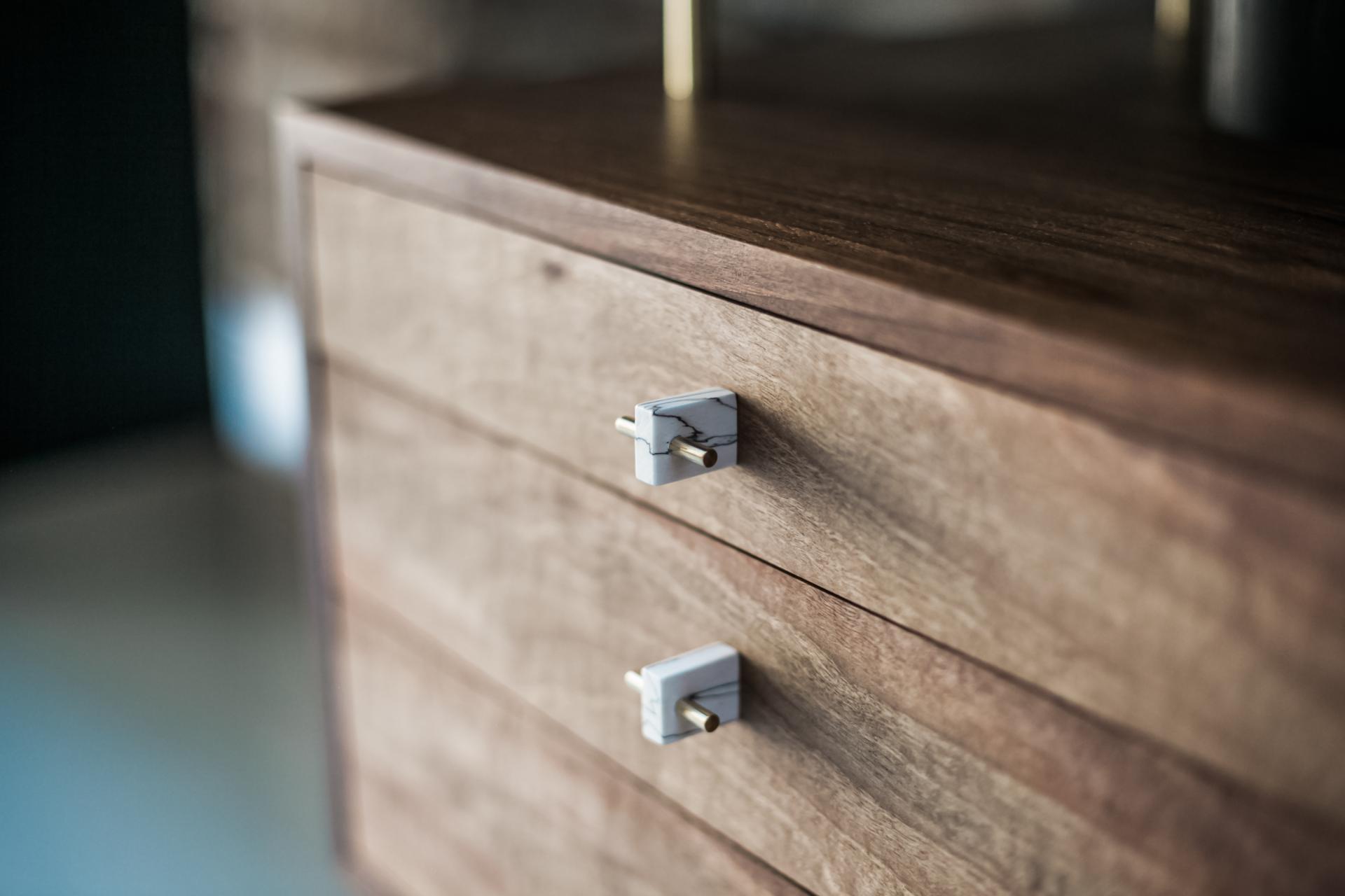 Elegant wooden furniture featuring marble handles, reflecting Robert Bain's focus on craftsmanship and sustainable materials.